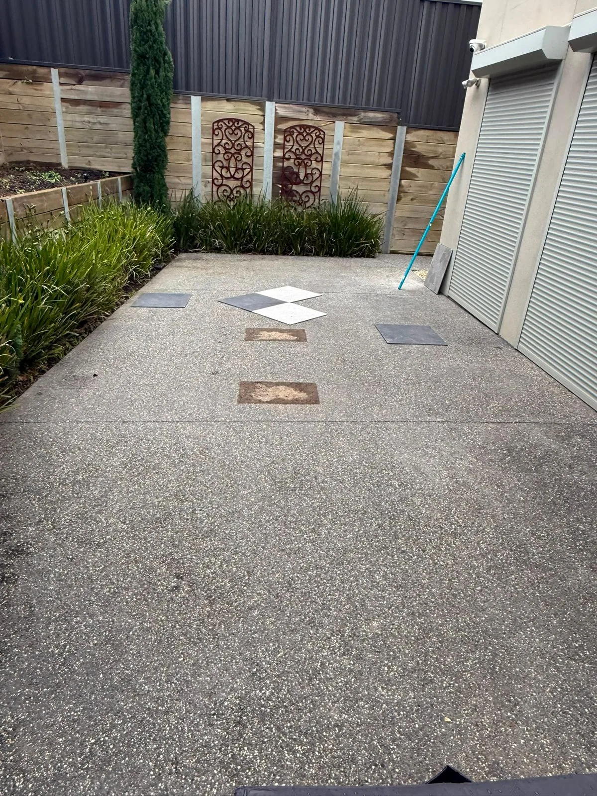 Side path before — bare aggregate concrete with sample tiles laid out